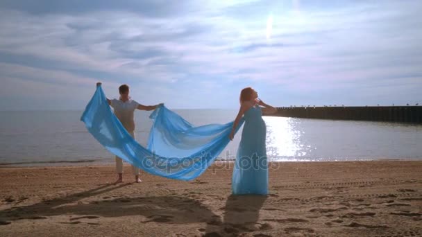 Mujer embarazada en el mar de playa. Mujer embarazada en vestido azul volando en el viento — Vídeo de stock