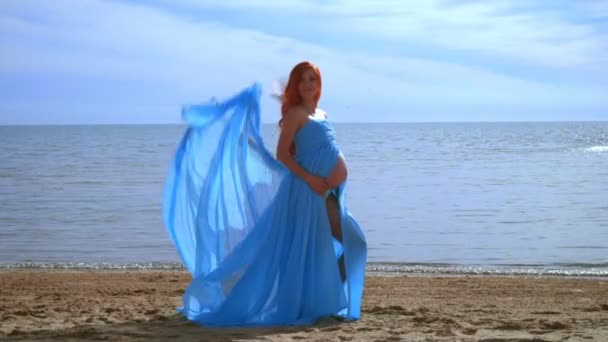 Беременная модель в синем платье летит на ветру. Романтическая фотосессия — стоковое видео