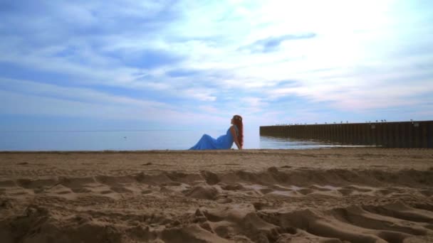 Mujer acostada en la playa de mar en vestido azul. Mujer embarazada relajándose en la playa — Vídeos de Stock