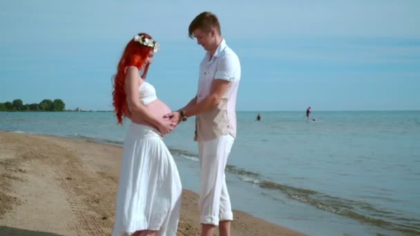 Plage de couple enceinte. Homme tenant ventre enceinte dans les mains. Attendre les parents — Video