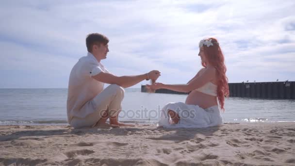 Pareja de amor vertiendo arena de manos en la playa. Pareja feliz divirtiéndose en la playa — Vídeo de stock
