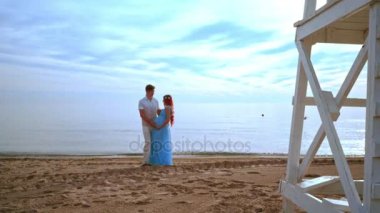 Sahilde anne bekliyor. Hamile çift sevgi ve bakım göbekle dokunmadan