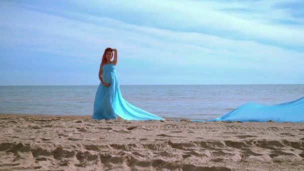 Mujer embarazada en vestido azul posando en la playa. Vacaciones en playa. Mujer romántica — Vídeo de stock