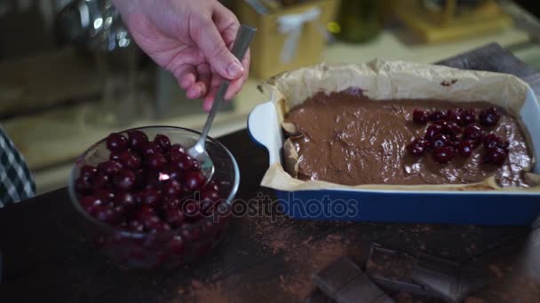 Mãos de homem adicionando cereja à massa de chocolate. Cozinhar bolo de chocolate. Brownie... — Vídeo de Stock