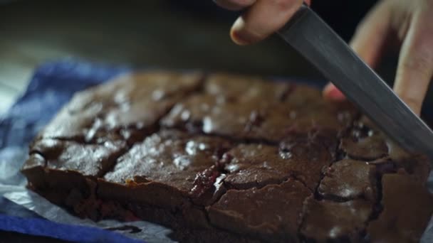Mãos masculinas cortando bolo de chocolate em fatias. Corte o bolo em pedaços. Bolo de corte — Vídeo de Stock