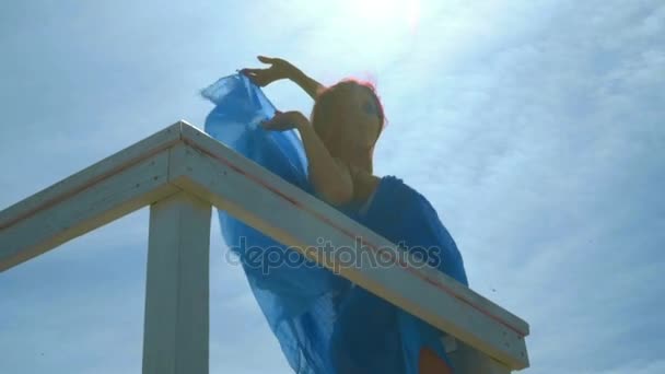 Donna felice sullo sfondo del cielo. Ritratto donna retroilluminazione. Vista ad angolo basso — Video Stock