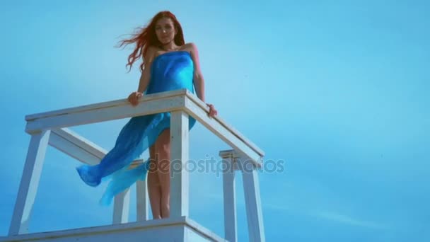 Redhead woman on watchtower on sky background. Bottom view of young woman — Stock Video
