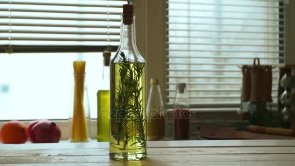 Frasco de aceite de oliva sobre mesa de madera. Aceite de oliva virgen extra con hierba de romero — Vídeo de stock