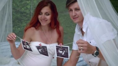Ultrason görüntüsü tutan hamile çift. Aşk çift portresi