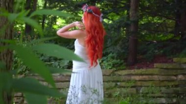 Adam yeşil orman Kızıl saçlı kadın casusluk. Beyaz elbiseli kızıl saçlı kadın