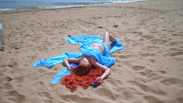Zrzavé vlasy žena na pláži. Zblízka těhotnou ženu ležící na pláži moře