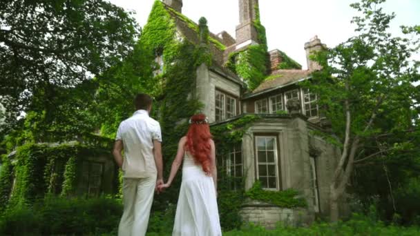 Honeymoon couple looking at beautiful country house. Fairytale house — Stock Video