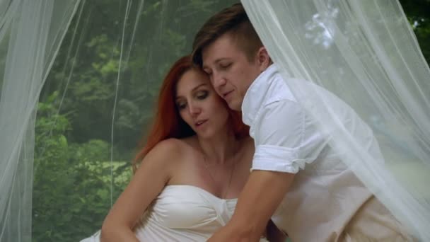 Romantisches Paar, das sich in Hochzeitsdekoration im Park umarmt. Partnersuche im Freien — Stockvideo
