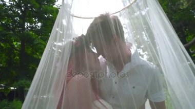 Çift öpüşme seviyorum. Hamile çift düğün peçe Park'ta arkasında öpüşme