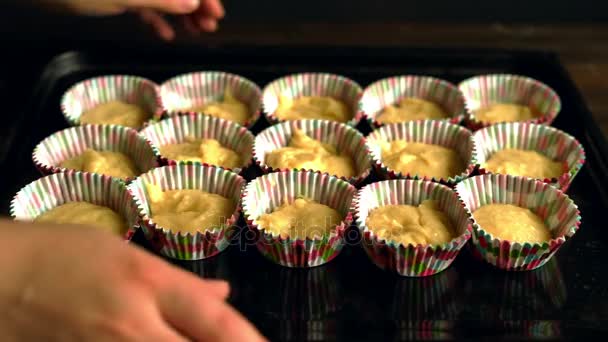 Kocken tar bakplåt med cupcakes. Matlagning cupcake. Degen i pappersformulär — Stockvideo