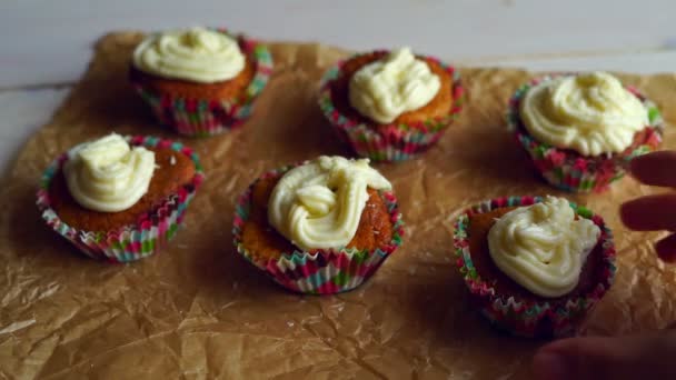 Koch nimmt einen Cupcake weg. sechs Cupcakes auf Kochpapier — Stockvideo