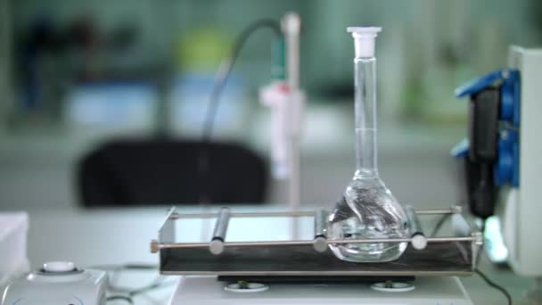 Glaskolben beim Laborschütteln. Nahaufnahme medizinischer Laborgeräte — Stockvideo