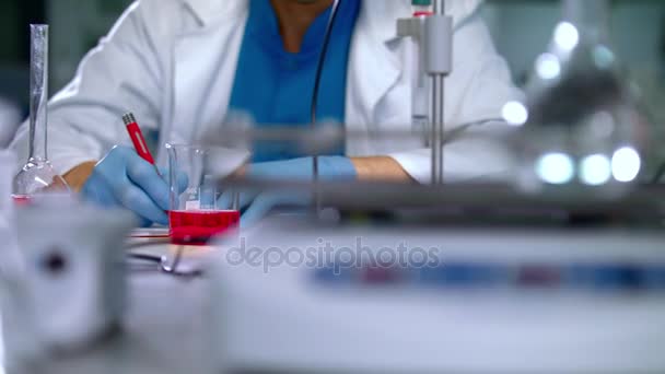 Pesquisador escrevendo dados de pesquisa com caneta no laboratório. Fechar as mãos dos cientistas — Vídeo de Stock