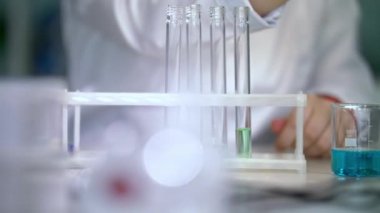 Kimyager sıvılar pipet ile tabloda test tüplere sokun