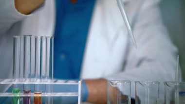 Bilim adamı dökme sıvı örnekleri test tüpleri eller. Laboratuvar donatımı