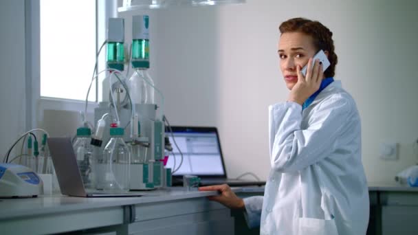 Vrouw wetenschapper praten over telefoon in laboratorium. Wetenschapper in lab — Stockvideo