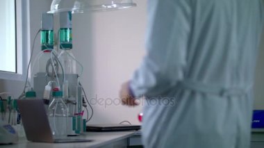 Bilim adamları laboratuarda. Bilim laboratuarında kimyasal sıvı ile cam şişesi getiriyor