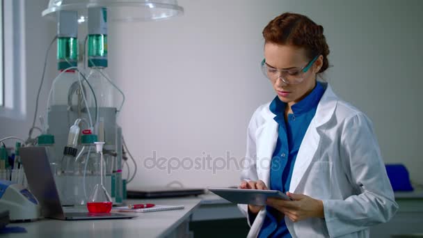 Θηλυκός επιστήμονας που εργάζεται με το tablet επιστήμονας. Ερευνητής που εργάζεται σε εργαστήριο. — Αρχείο Βίντεο