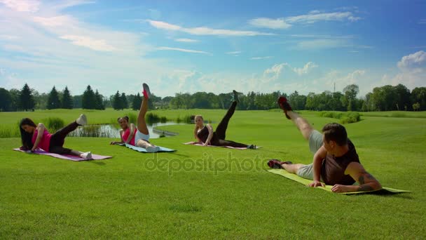 Lezione di aerobica all'aperto. Fitness trainer che mostra l'esercizio delle gambe al parco estivo — Video Stock