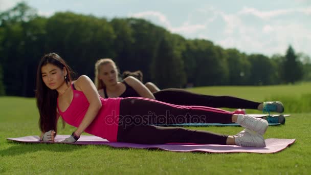 Ejercicio en grupo al aire libre en parque. Grupo deportivo multiétnico haciendo ejercicio de piernas — Vídeos de Stock