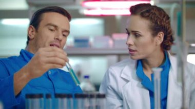 Laboratuarda çalışan bilim adamı takım. Test tüpü içinde sıvı örnek tartışırken bilim adamı