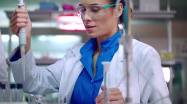 Bilim adamı öğrenci kimyasal laboratuvar şişesi pipet ile sıvı dökme