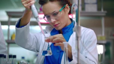 Kimyasal reaktifler ile çalışan bilim adamı kadın. Laboratuvar şişesi içinde kimyasal reaksiyon