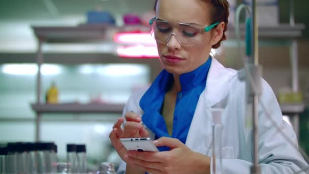 Medicinska forskare att skriva på telefonen i lab. Laboratorietekniker som använder telefon i lab — Stockvideo