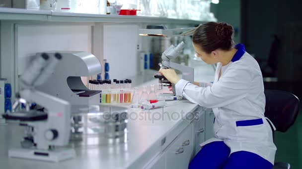 Investigador de laboratorio trabajando con microscopio en laboratorio — Vídeos de Stock