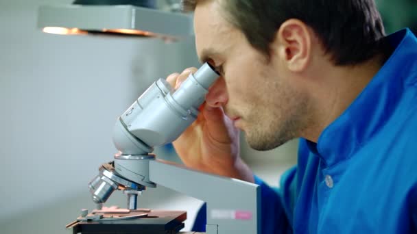 Male researcher working with microscope. Research medical microscope — Stock Video