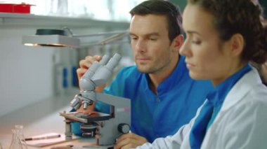 Laboratuarda çalışan doktorlar ekibi. Laboratuvar bilim adamı mikroskop ve tablet pc ile çalışma