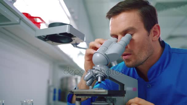 Étudiant scientifique travaillant au microscope. Homme scientifique à la recherche de microscope 
