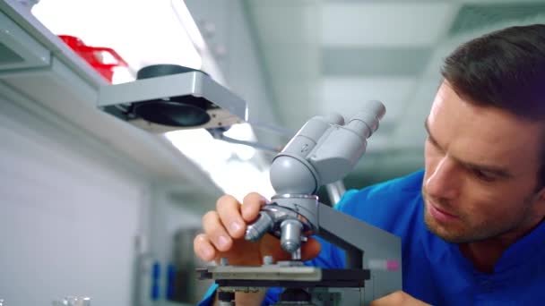 Investigador trabajando con microscopio en laboratorio. Doctor haciendo investigación de microscopio — Vídeo de stock