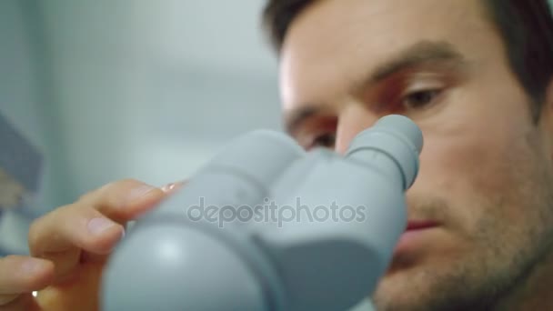 Microscopio de aspecto facial científico. Primer plano del microscopio científico que mira — Vídeos de Stock