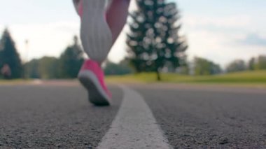 Afrikalı kadın spor ayakkabı bacaklarda asfalt yolda çalışmaya başlar