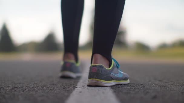 Αθλήτρια τα πόδια αρχίζουν να τρέχουν στο δρόμο. Κοντινό πλάνο Γυναίκα πόδια σε παπούτσια για τρέξιμο — Αρχείο Βίντεο