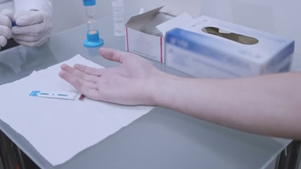 Dottore che preleva campioni di sangue dalla mano maschile. L'uomo dona il test delle dita del sangue — Video Stock