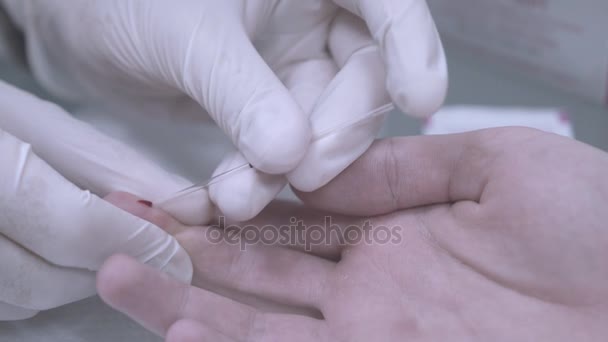 Анализ крови пальцев. Закрытие рук в перчатках, взятие образца крови. Медицинский тест — стоковое видео