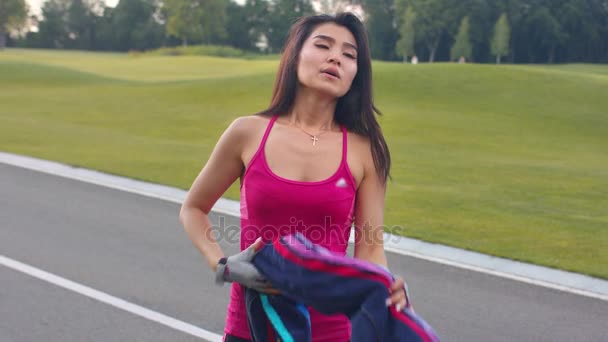 Trött kvinna efter konditionsträning i park. Trött asiatiska löpare — Stockvideo