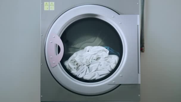 industrielle Waschmaschine, die Wäsche wäscht. Nahaufnahme einer funktionierenden Waschmaschine