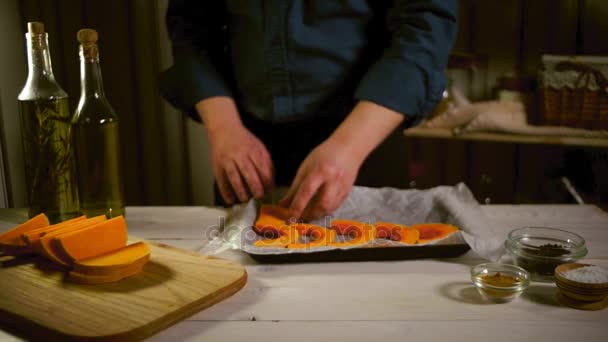 Nyers sütőtök darabokat sütésre kész. Chef sütőtök szeleteket tedd tepsibe — Stock videók