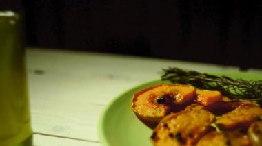 Biberiye bitki ile pişmiş kabak dilimleri. Fırında kabak parçaları