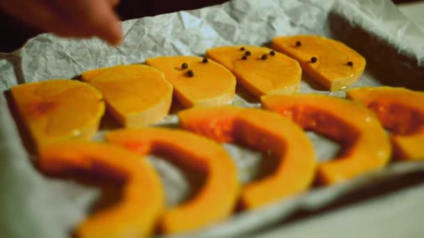 Hände aus nächster Nähe gießen Paprika-Kürbisscheiben auf Backblech. gesunde Ernährung — Stockvideo