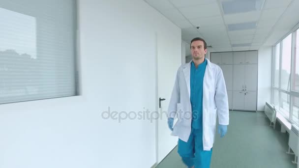 Doktoren går gjennom gangen. Steadyshot av medisinsk arbeider i laboratoriekorridor – stockvideo
