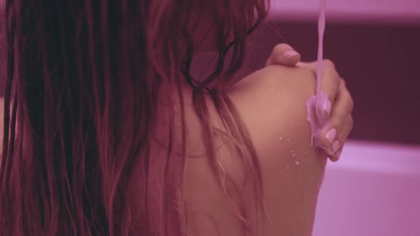 Naakte achterkant naakt meisje. Giet blote schouders met melk en terug in Bad — Stockvideo